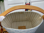 Louis Vuitton bag interior view with light blue monogram lining and tan leather top rim