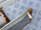 Louis Vuitton monogram pouch with gold zipper and tan leather trim, close-up detail