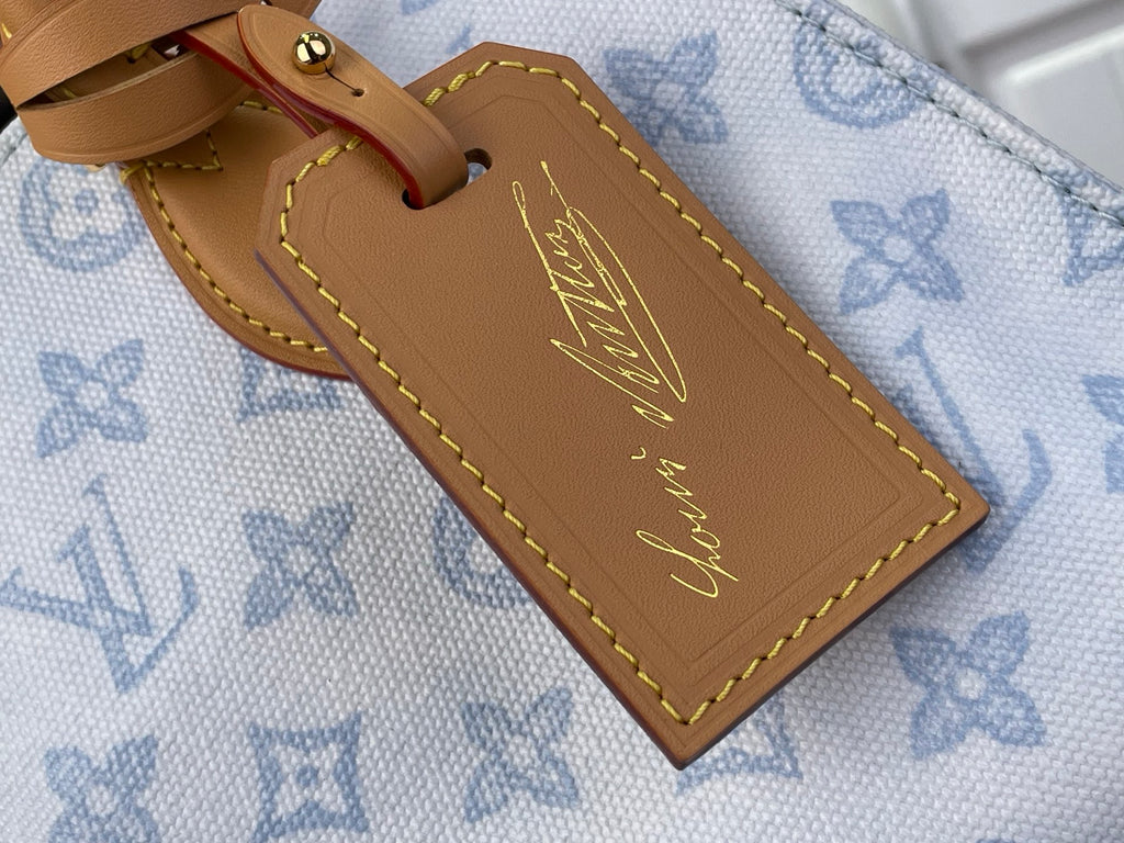 Louis Vuitton tan leather name tag on blue monogram tote with gold edge stitching