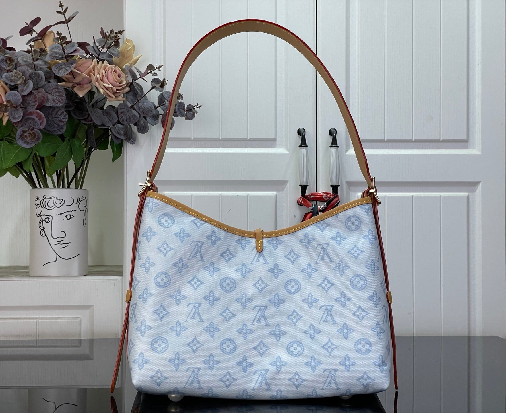 Hobo bag in light blue monogram canvas with curved tan shoulder strap