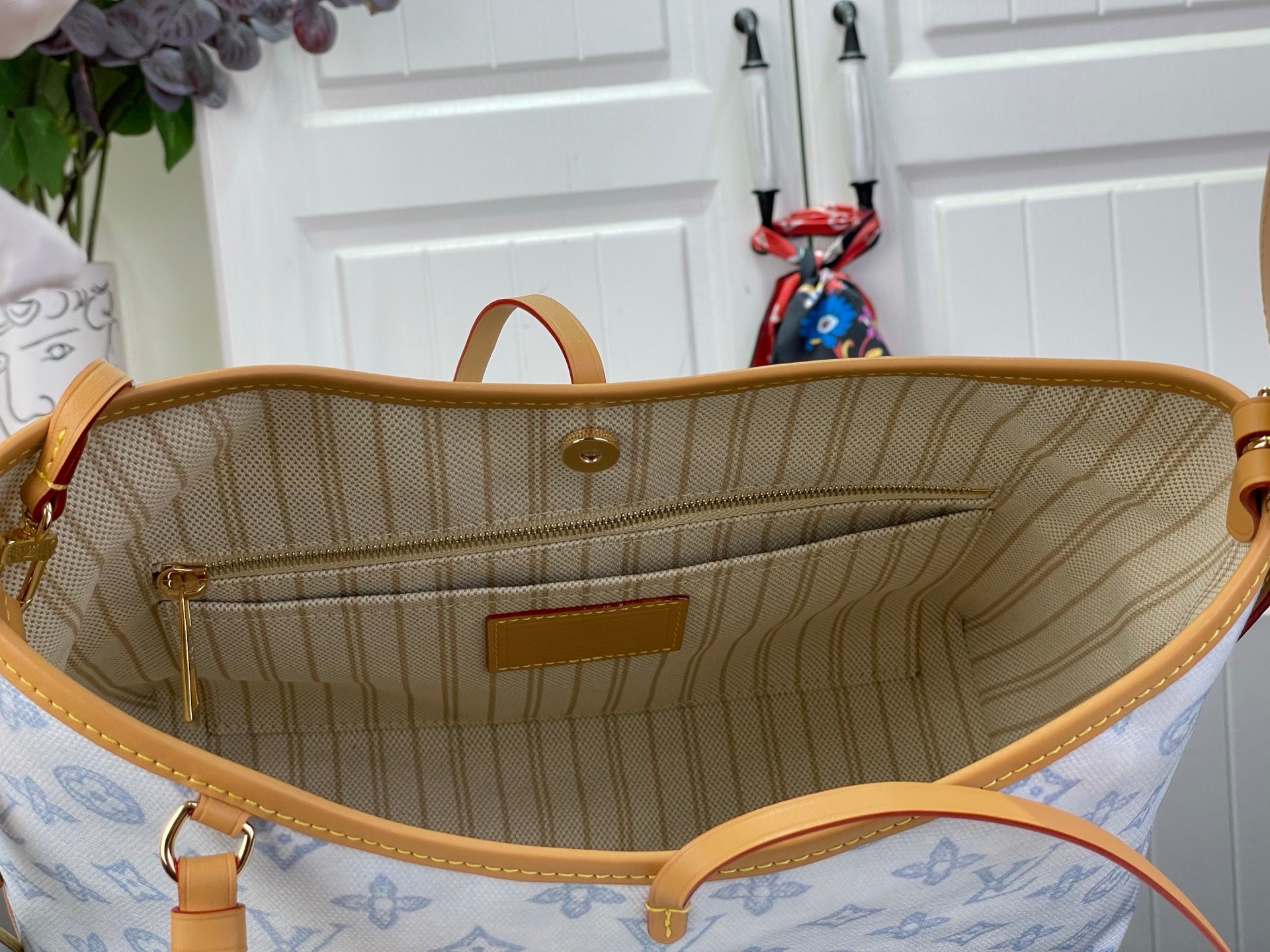 Open hobo bag showing tan striped lining and front pocket inside