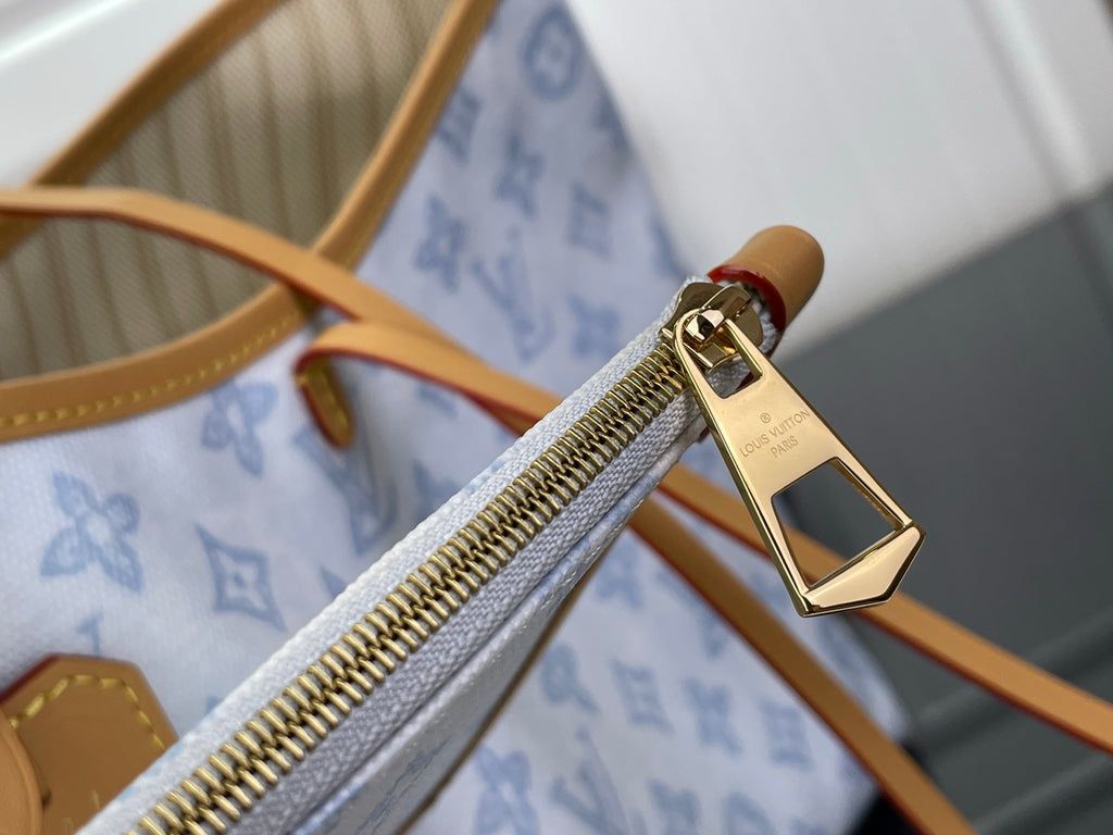 Louis Vuitton bag zip pull with gold hardware and tan leather trim