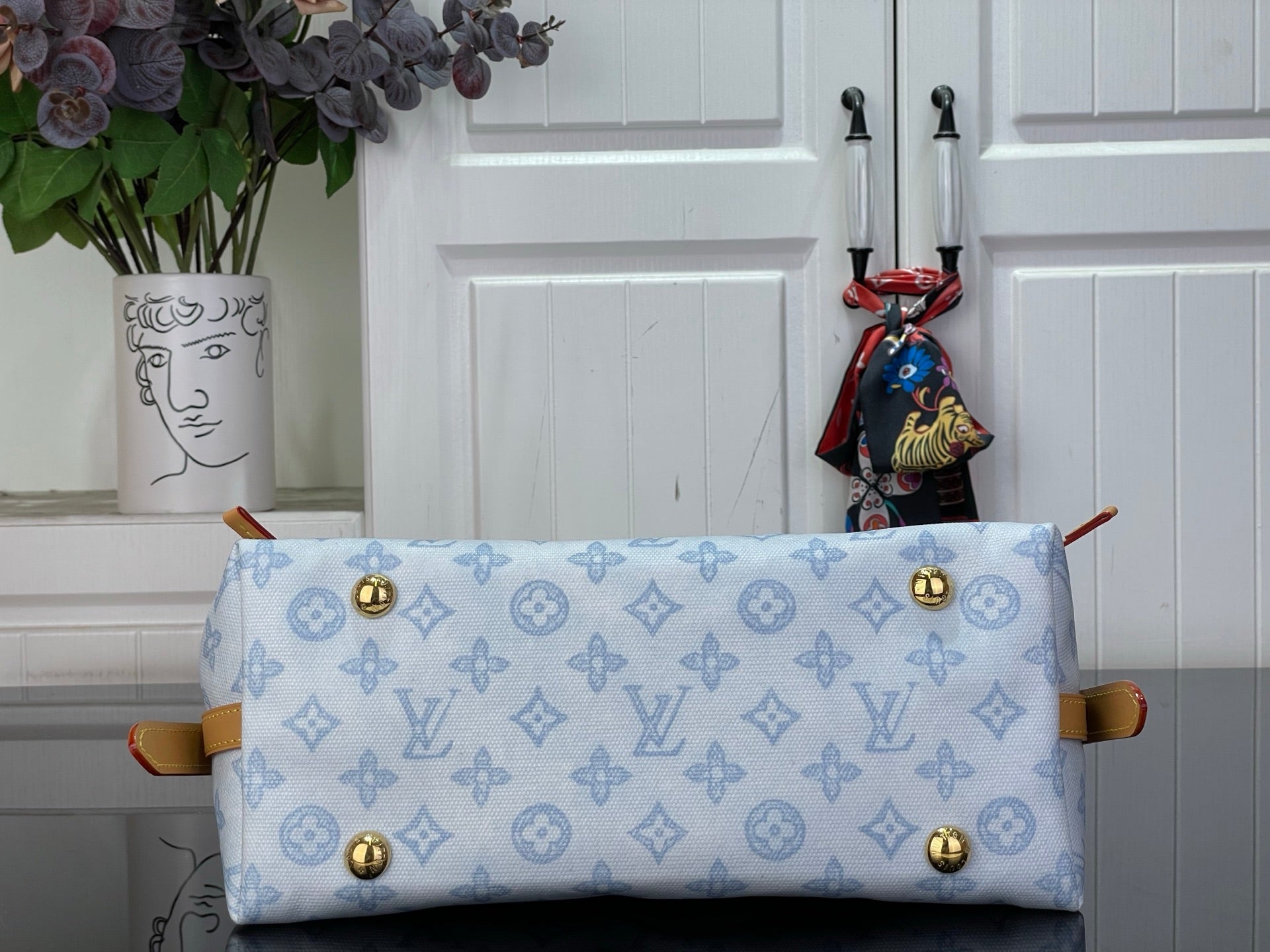Hobo bag front panel with gold snap buttons and light blue monogram canvas