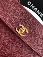 Chanel handbag front flap with burgundy textured leather and gold interlocking logo