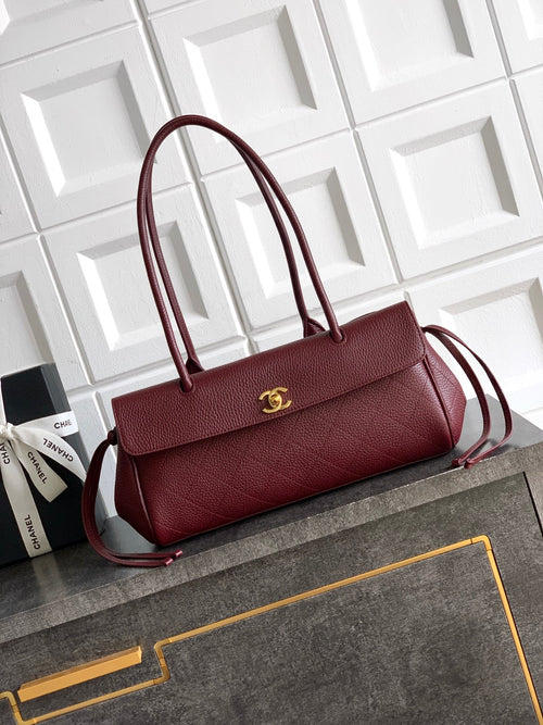 Chanel handbag in burgundy with top handles, shoulder strap, and gold logo hardware
