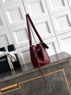 Chanel burgundy mini handbag with tall handles and crossbody strap, gold logo detail