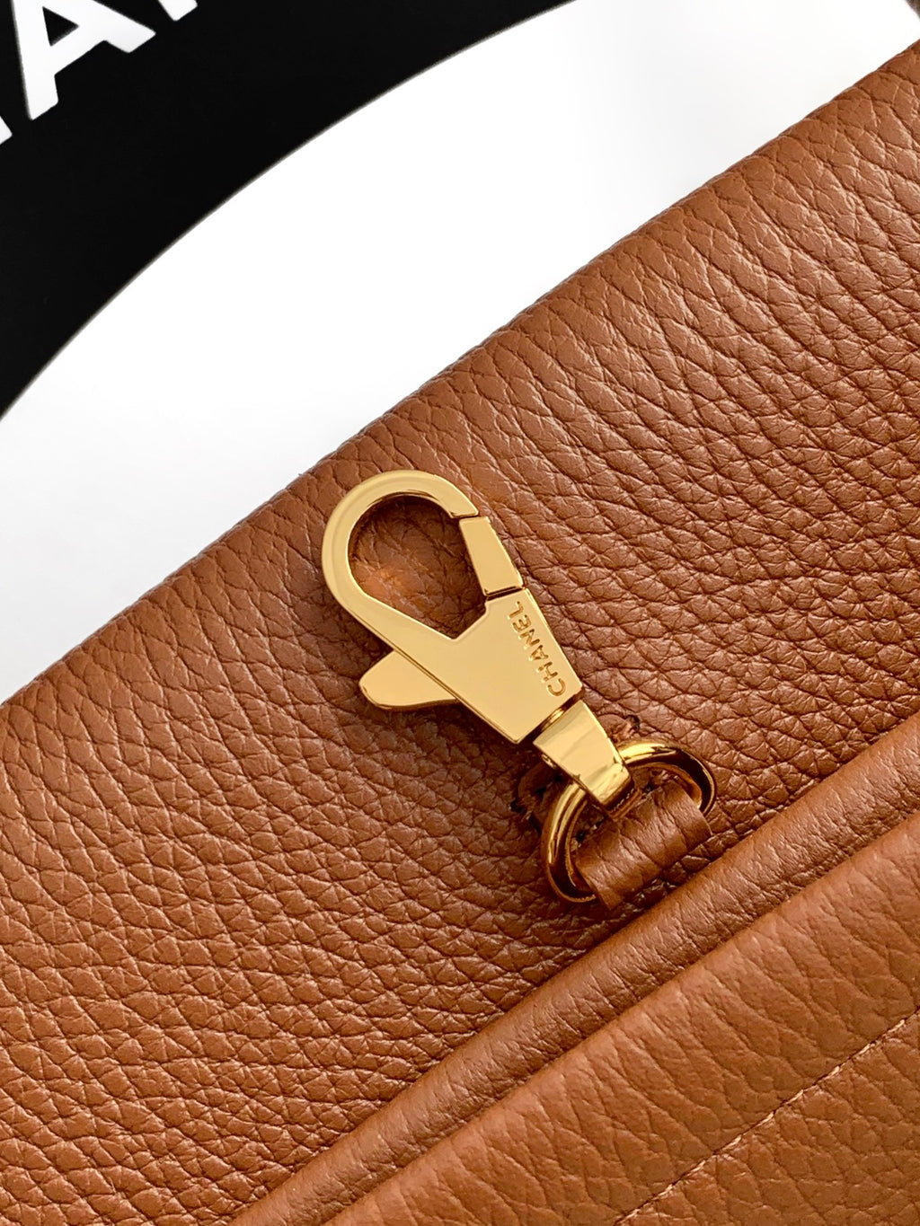 Chanel brown leather strap connector with gold-tone clasp and engraved emblem