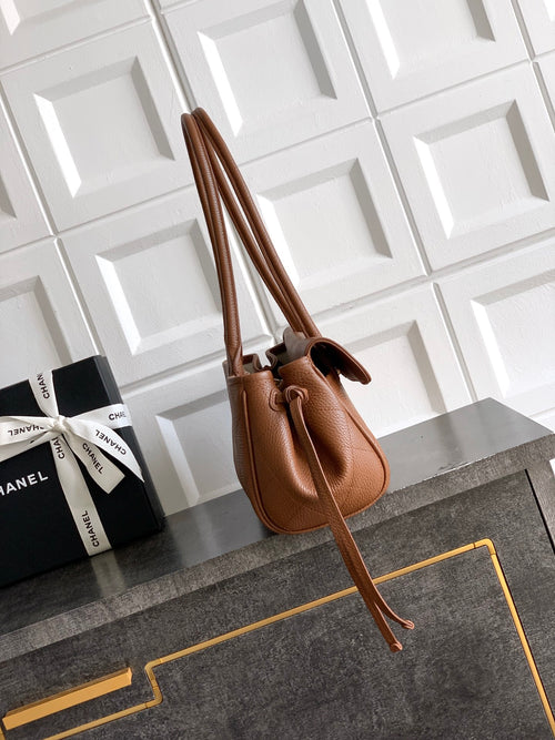 Chanel brown leather handbag with dual top handles and side cords, gold accents