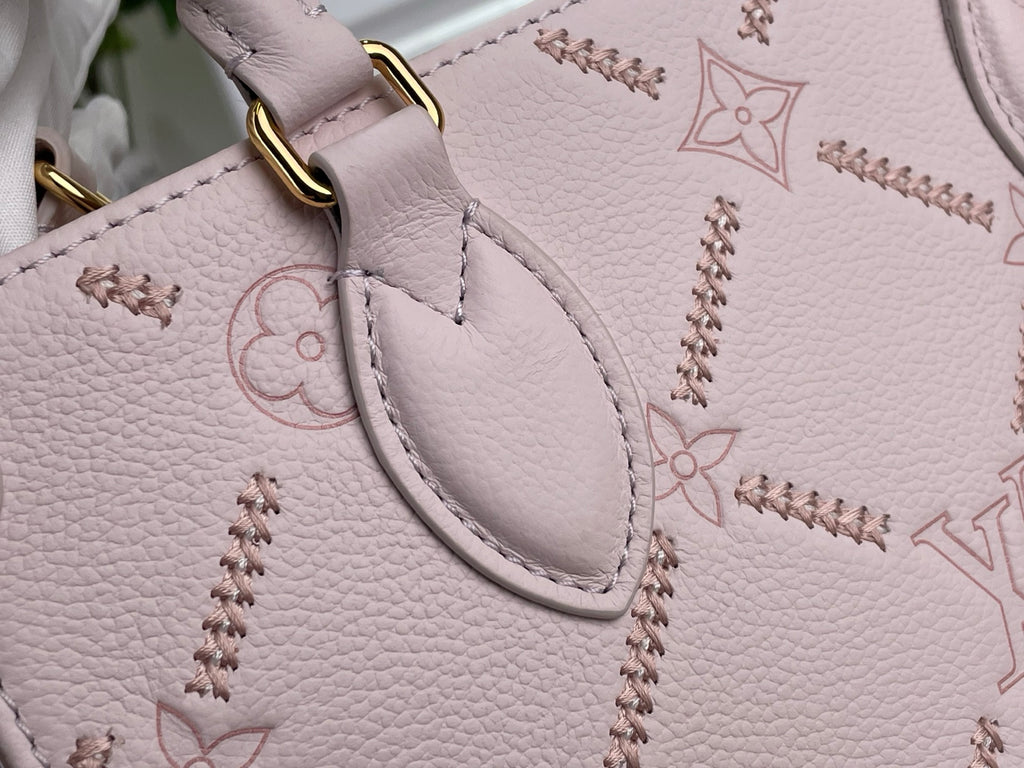 Light pink monogram tote bag corner with curved stitched trim and gold ring attachment