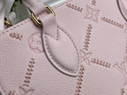 Light pink monogram tote bag corner with curved stitched trim and gold ring attachment