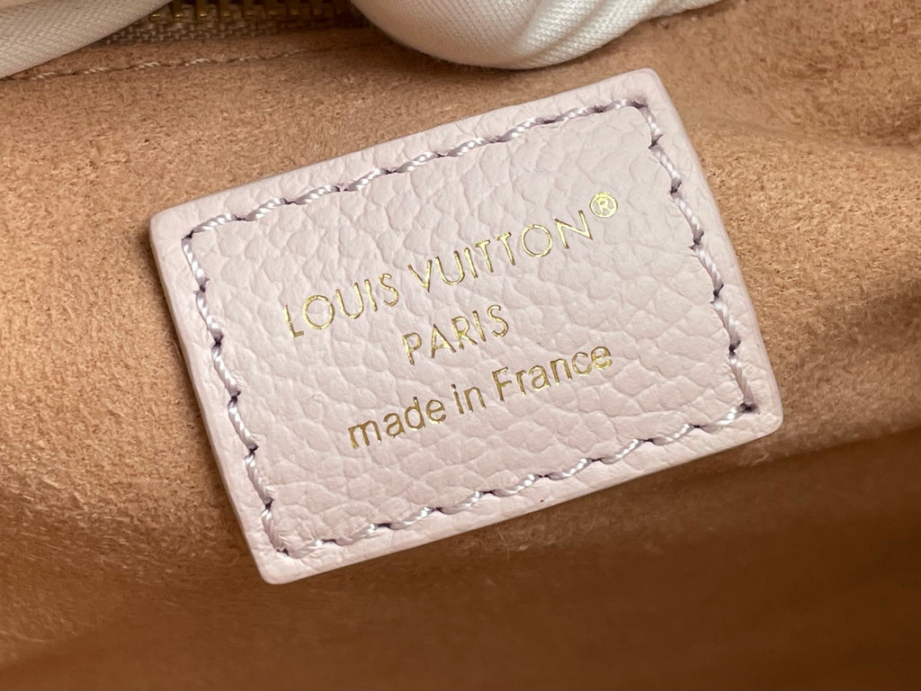 Louis Vuitton bag leather label, embossed logo and stitching on light beige