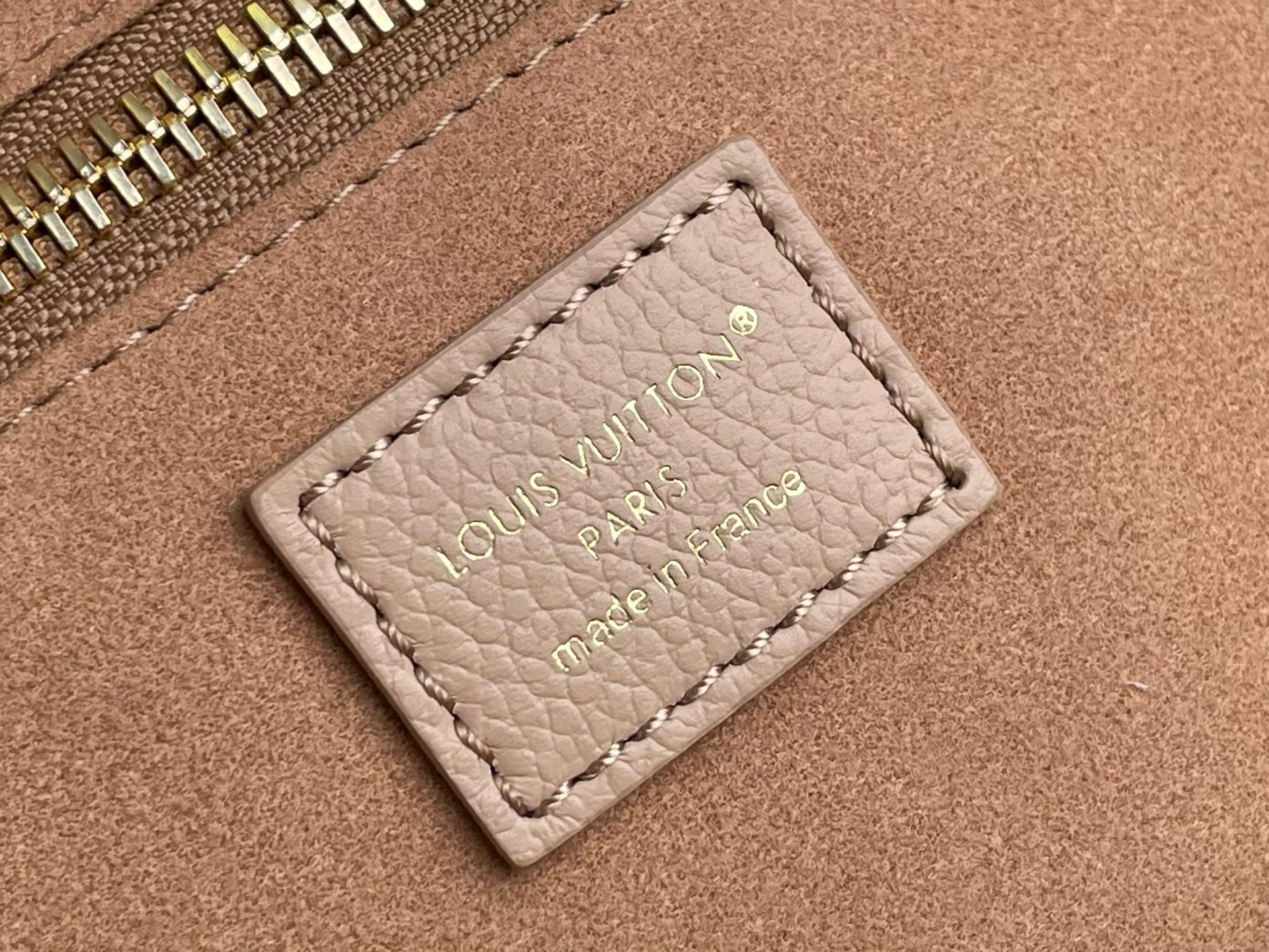 Louis Vuitton taupe leather card holder with engraved “Louis Vuitton” text