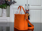 Orange leather-look tote bag with long shoulder strap and top handles
