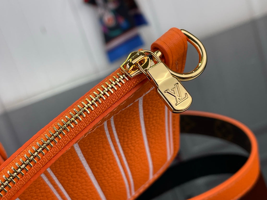 Orange bag close-up of gold zipper and ring pull on top edge