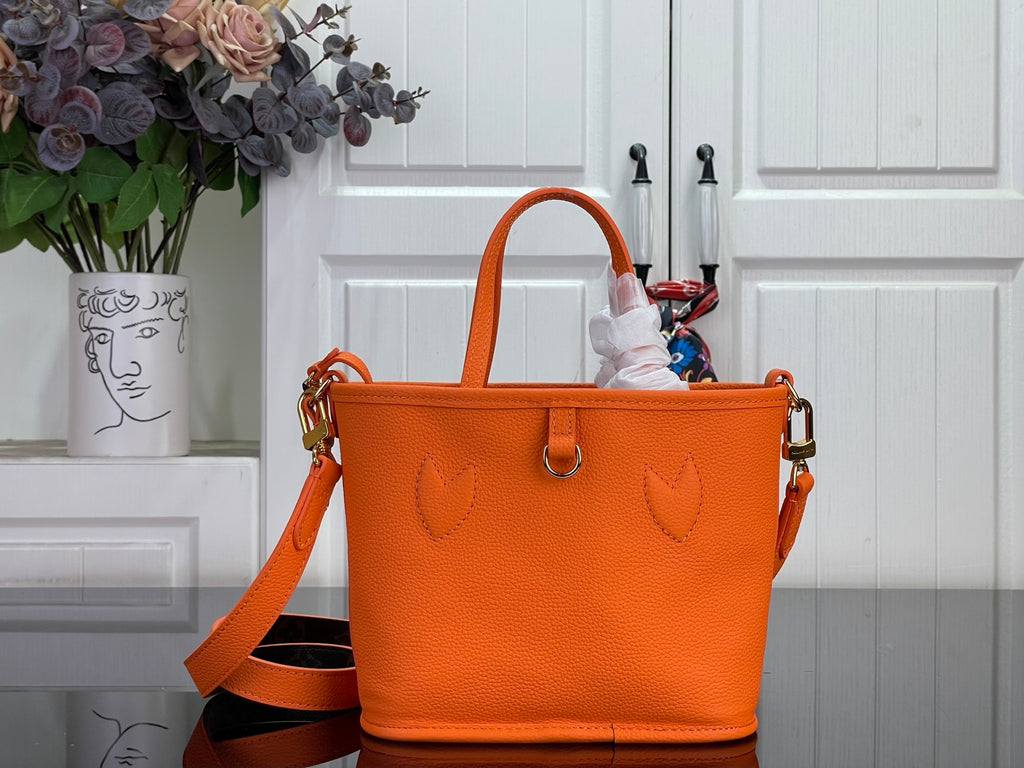 Orange leather-look tote bag with dual handles and gold side hardware