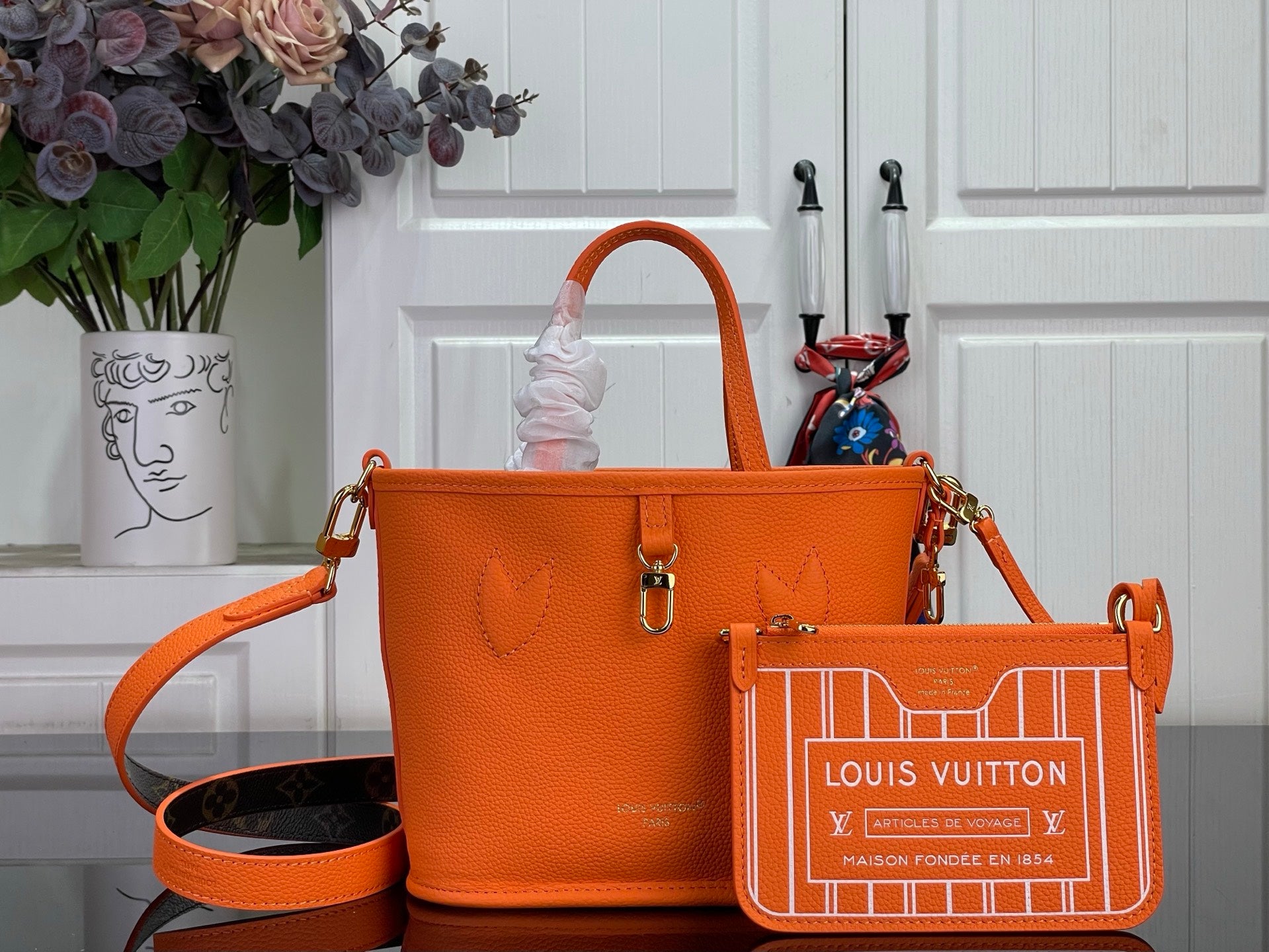 Orange leather-look tote bag with gold hardware and shoulder strap