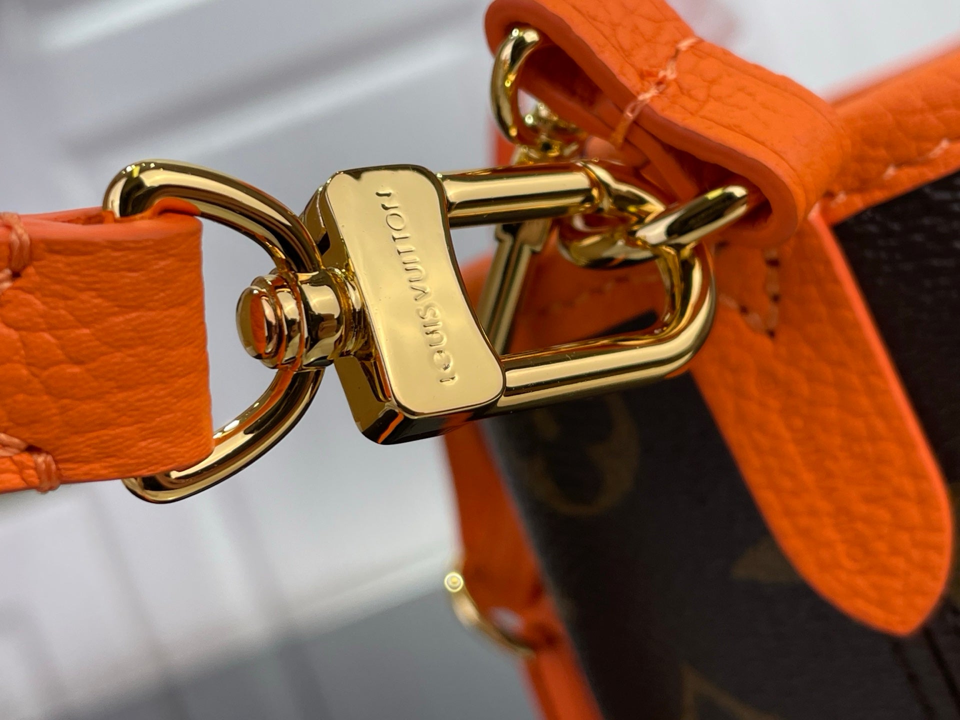 Louis Vuitton orange leather hardware with gold clasp and key ring attachment