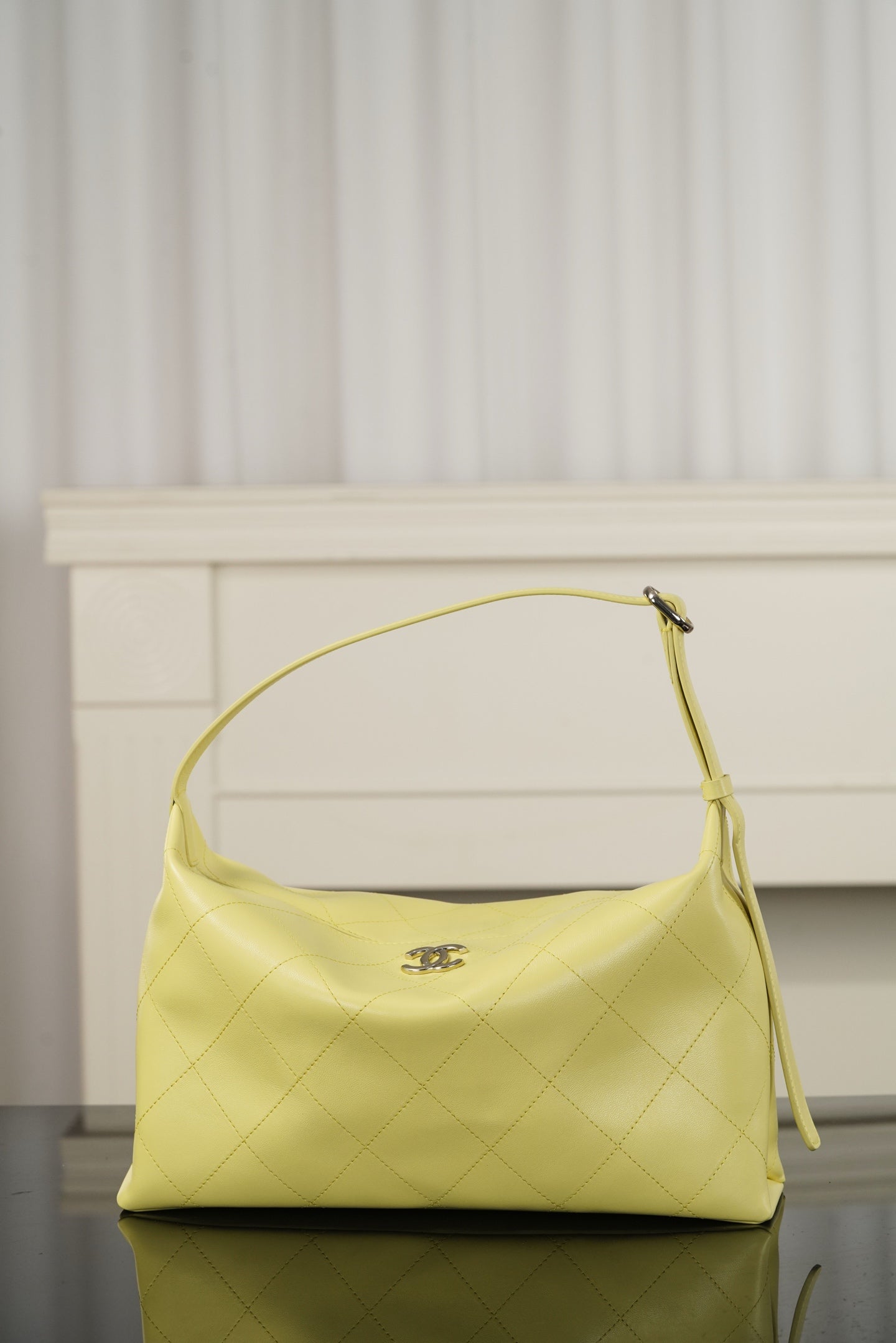 Chanel hobo bag in light yellow leather with top handle and slouchy silhouette, gold-tone hardware
