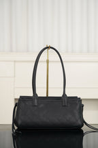 Chanel handbag with structured top, dark quilt-textured leather, gold logo clasp, handles