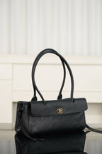 Chanel handbag in dark textured leather, flap with gold logo, side angle with strap