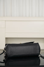 Chanel shoulder bag in dark leather with gold zipper pull, side view and strap