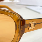 Close-up of amber sunglasses arm with gold-tone logo detail and hinge