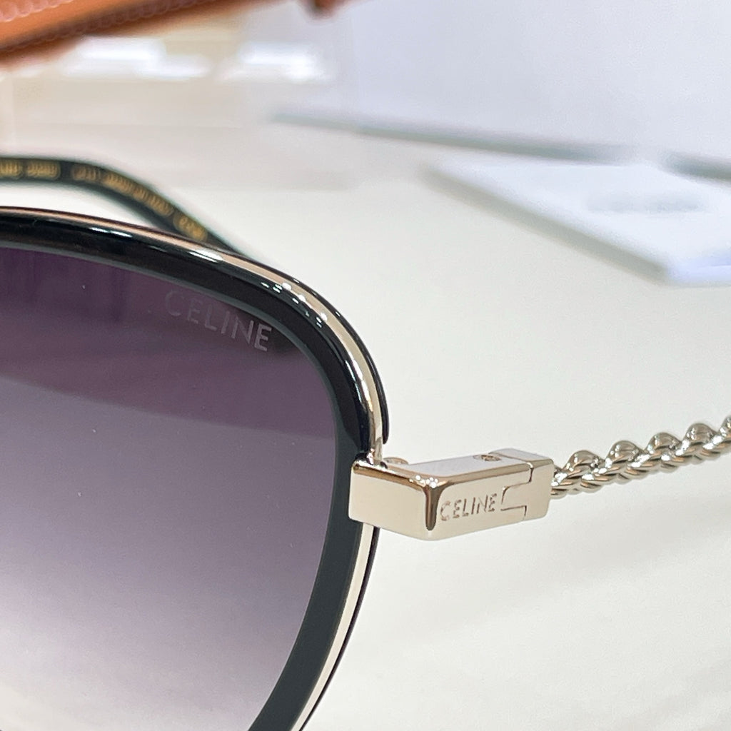 Sunglasses close-up: gold-tone hinge with Celine logo and chain temple