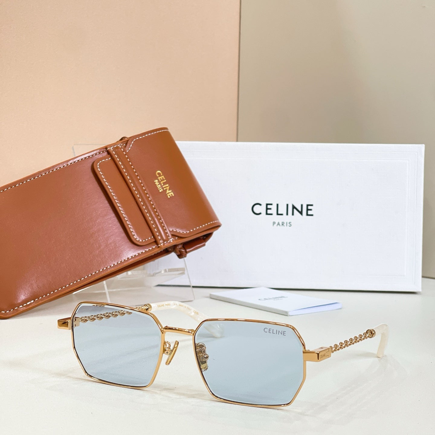 Gold-tone square sunglasses with light blue lenses and chain temples