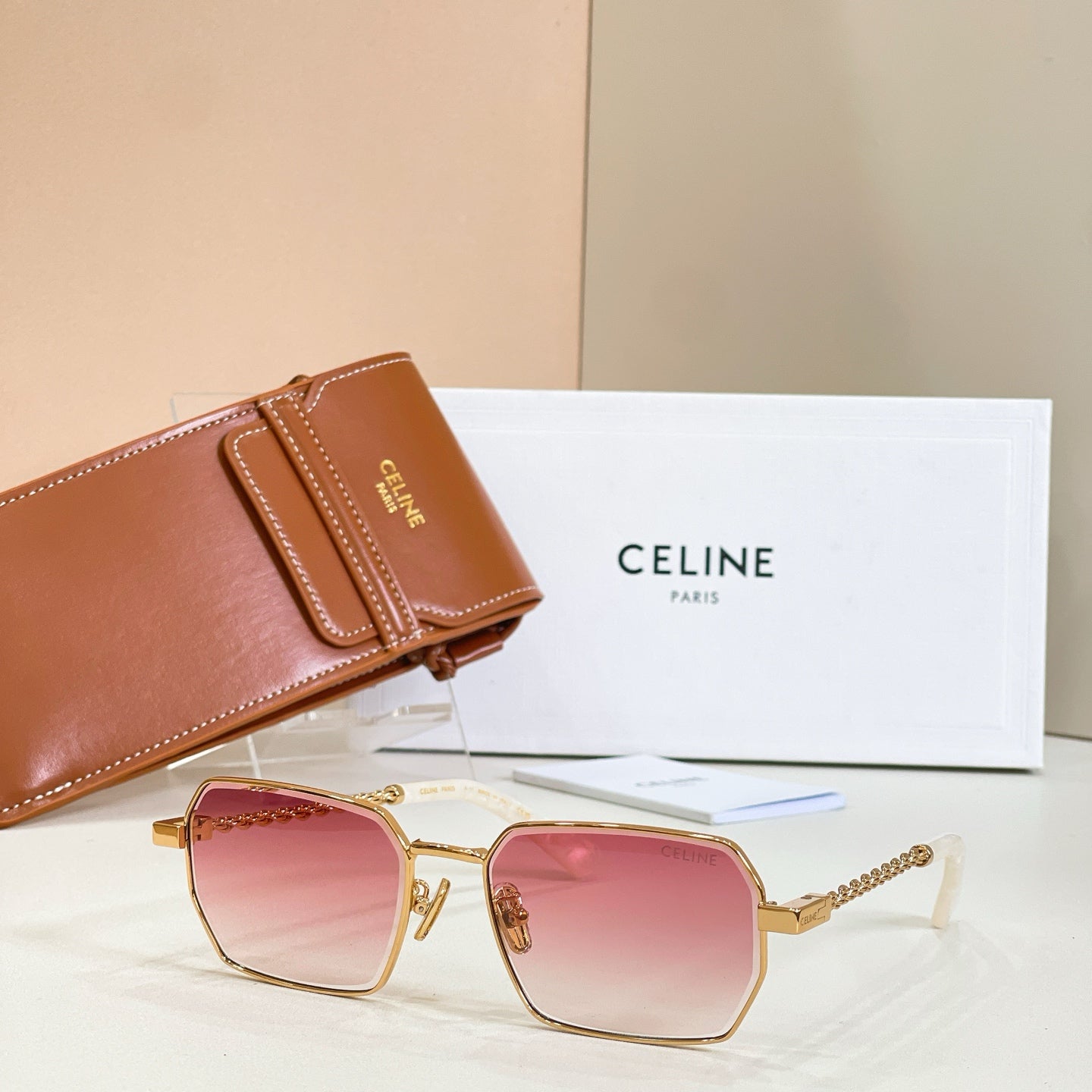 Gold-tone square sunglasses with pink gradient lenses and chain temples
