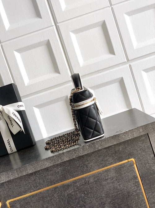 Black quilted mini handbag with chain strap, single top handle and gold-tone trim