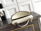 Cream quilted mini bag with rounded top and chain handle, gold-tone zipper