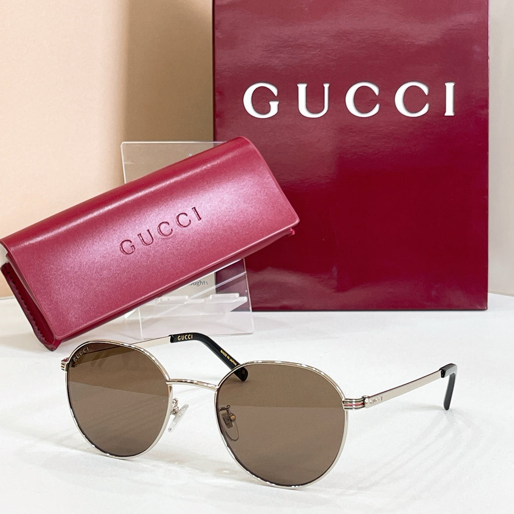 Round gold sunglasses with brown tinted lenses and slim metal temple arms