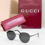 Round black sunglasses with dark lenses and slim metal temples