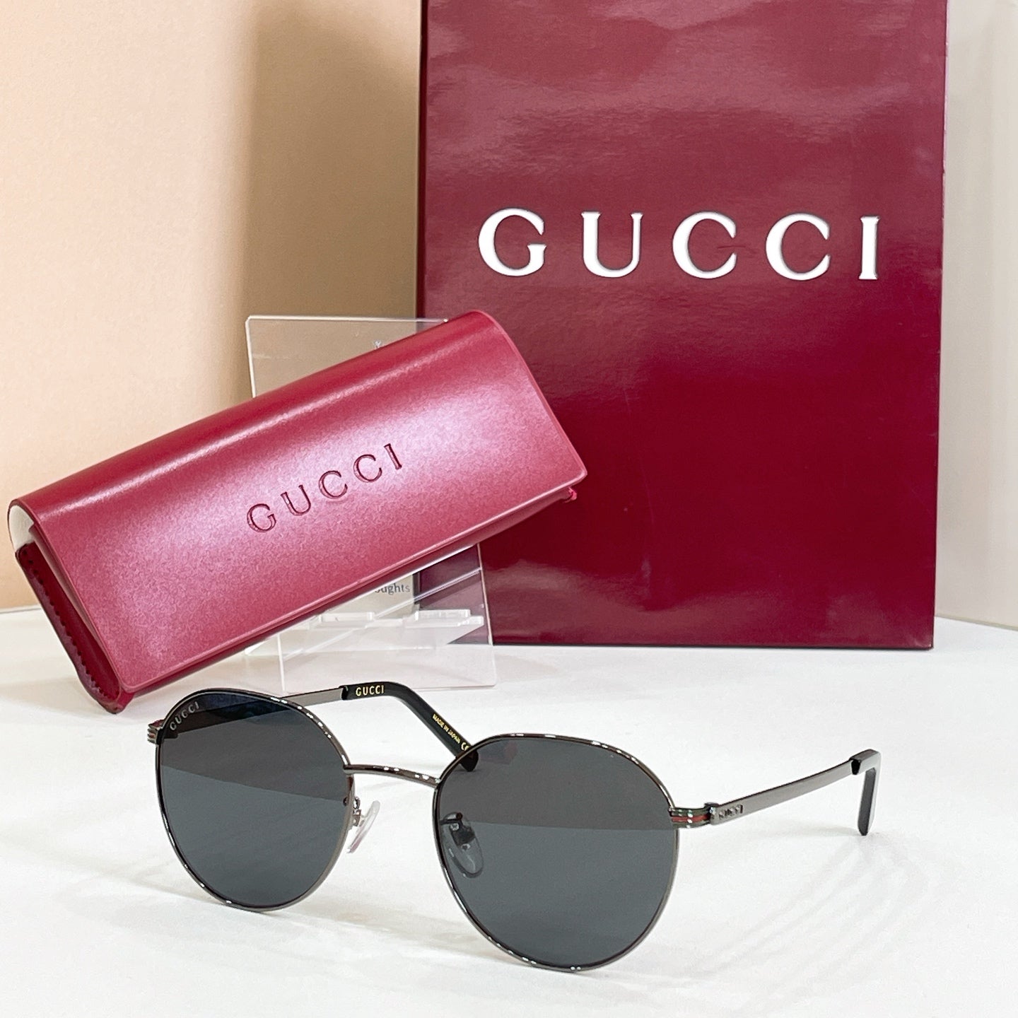 Round black sunglasses with dark lenses and slim metal temples