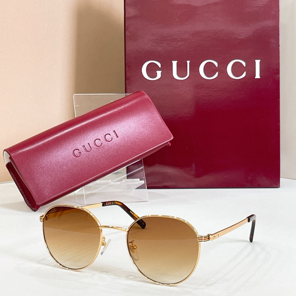 Round gold sunglasses with amber tinted lenses and thin metal temples