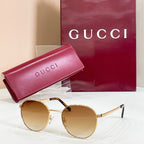 Round gold sunglasses with amber tinted lenses and thin metal temples