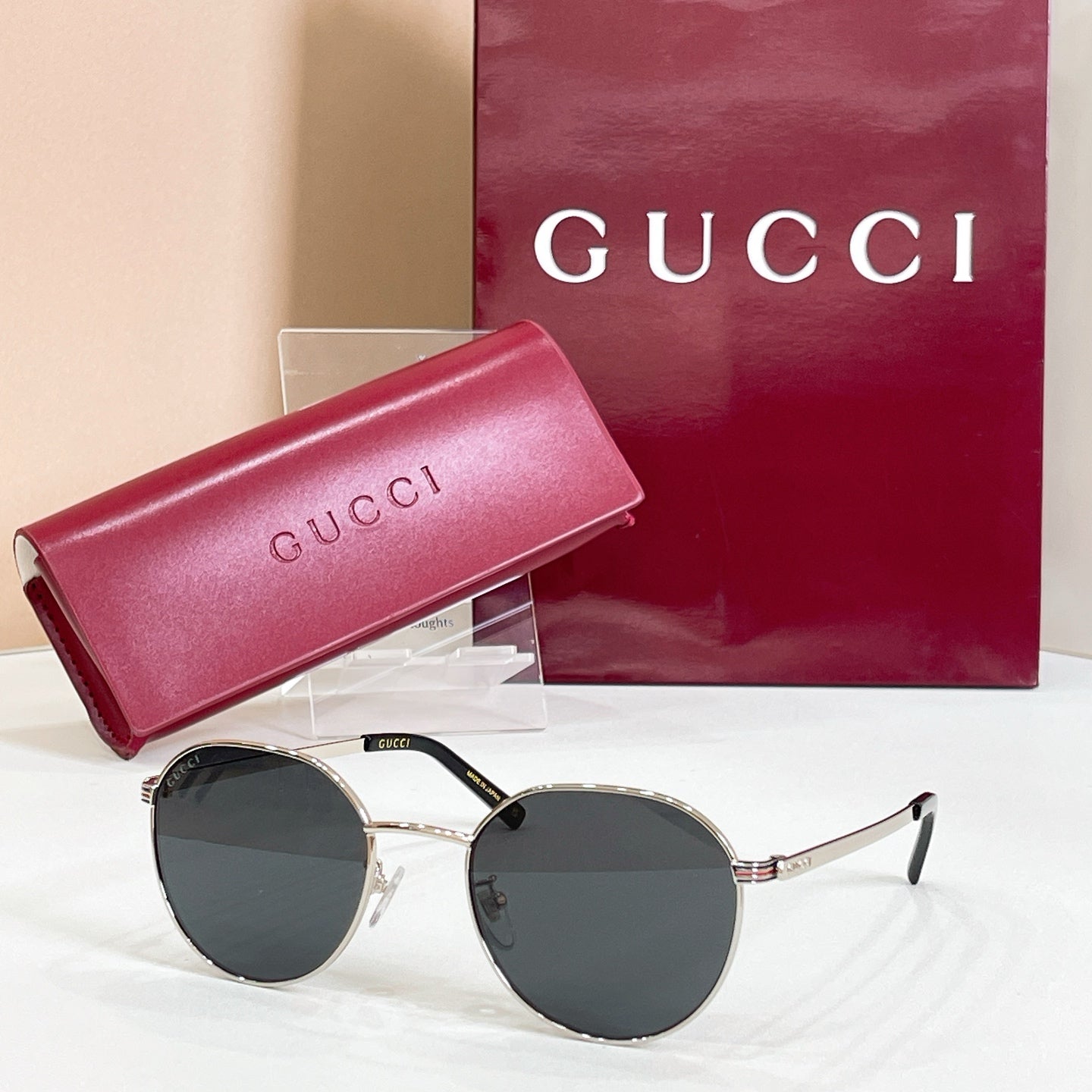 Round gold sunglasses with dark lenses and metal temple arms with logo detail
