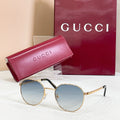 Round gold sunglasses with blue tinted lenses and thin metal temples