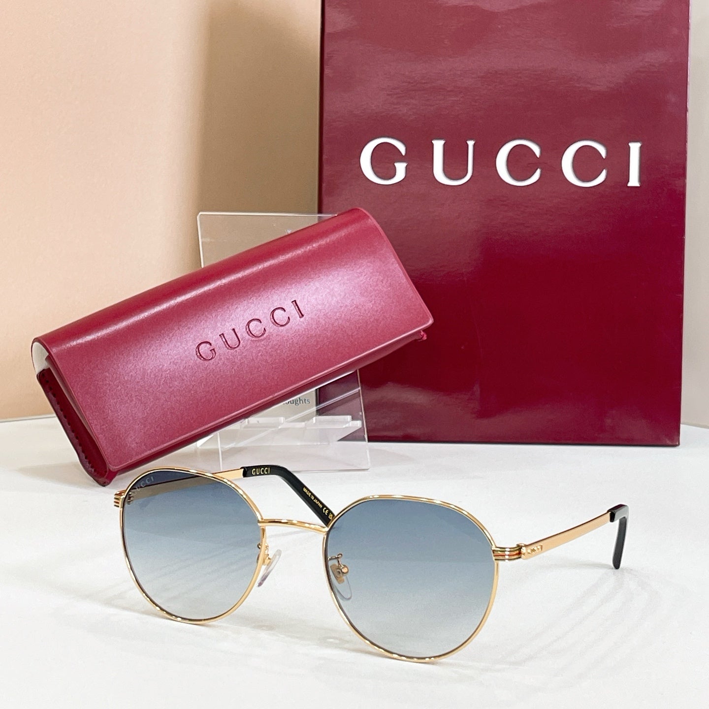 Round gold sunglasses with blue tinted lenses and thin metal temples