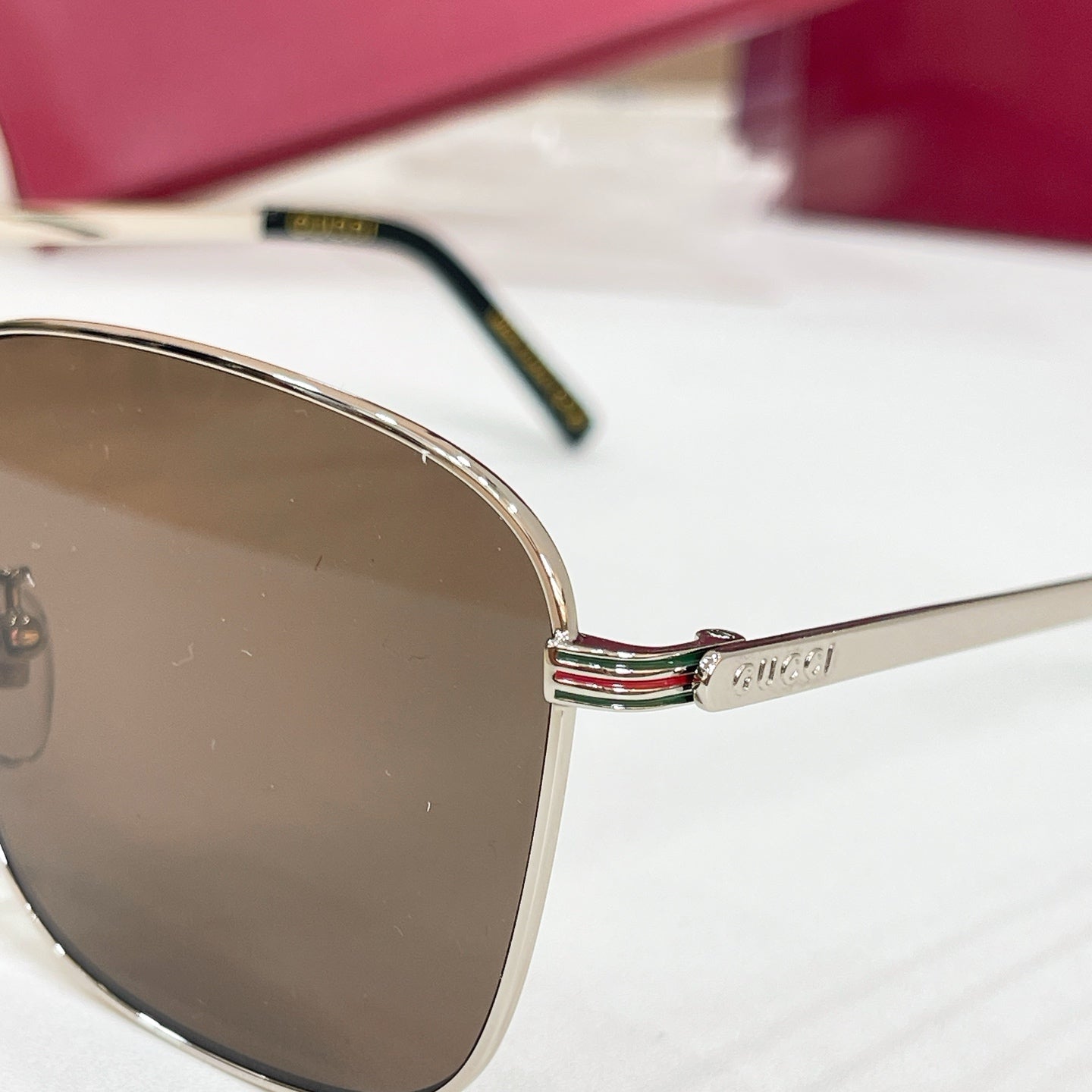 Sunglasses temple and lens close-up with gold logo detail