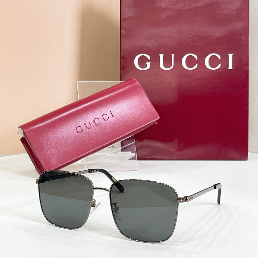Square sunglasses with silver and black frame, dark lenses, and pink logo case