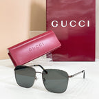 Square sunglasses with silver and black frame, dark lenses, and pink logo case