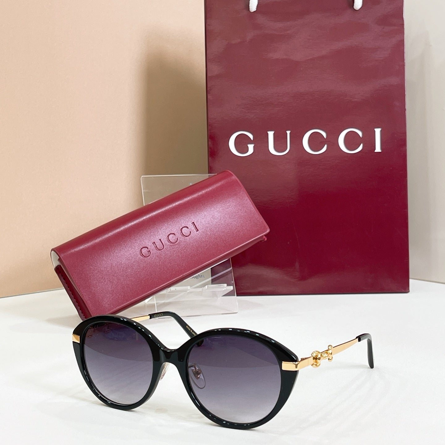 Black round sunglasses with gold-tone accents and purple-tinted lenses