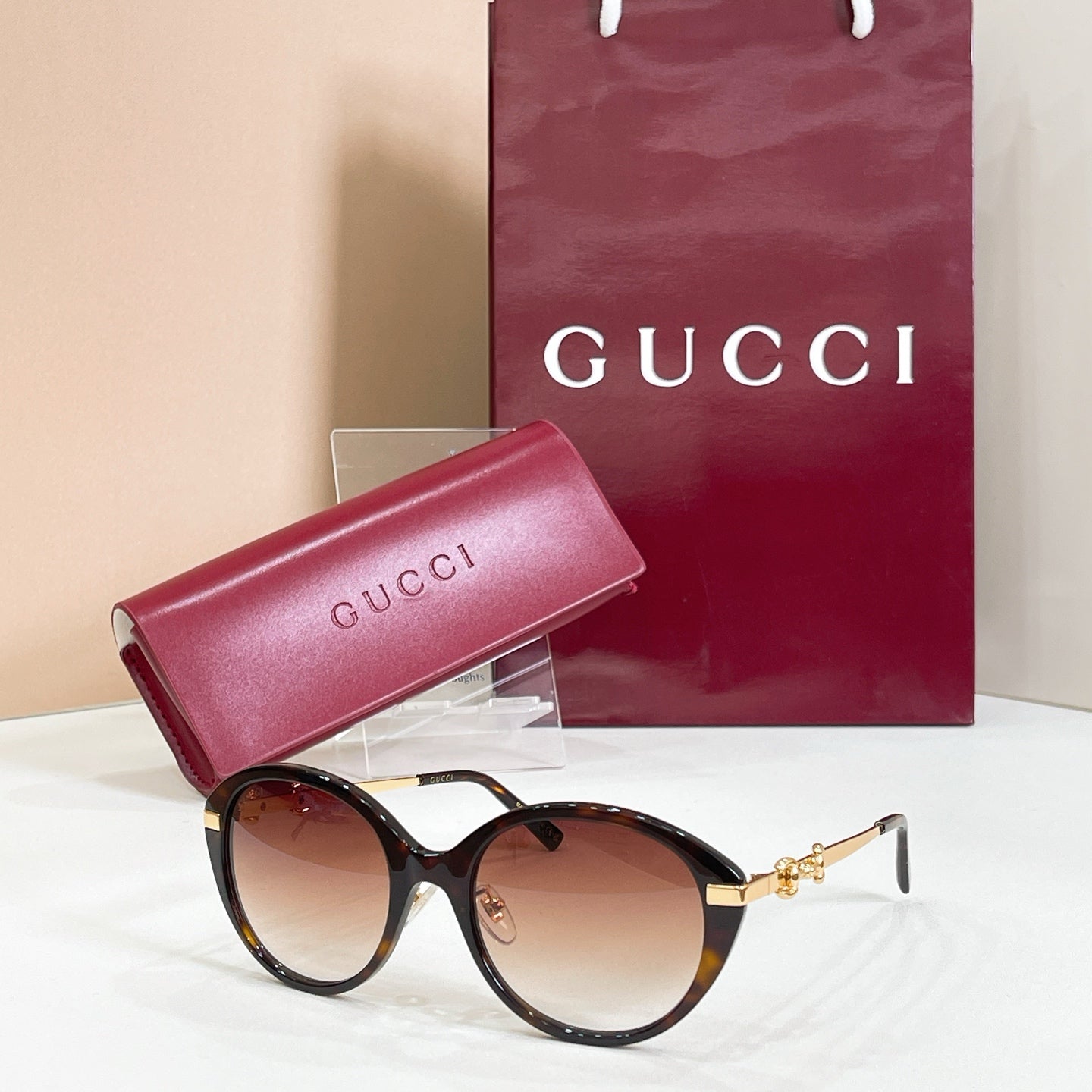 Black round sunglasses with gold-tone accents and brown-tinted lenses