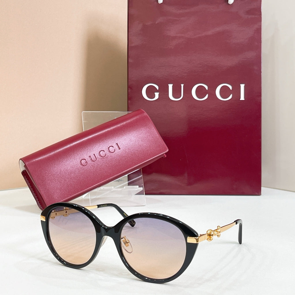 Black round sunglasses with gold-tone accents and dark-tinted lenses