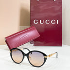 Black round sunglasses with gold-tone accents and dark-tinted lenses