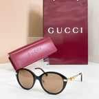 Black round sunglasses with gold-tone hinges and tinted lenses