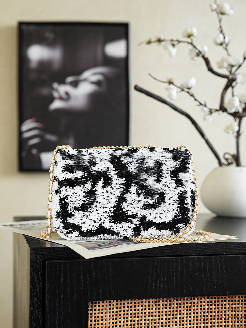 Black-and-white sequin shoulder bag with gold chain and front logo flap