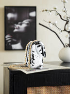 Black-and-white sequin shoulder bag, side view with gold chain strap