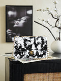Black-and-white sequin shoulder bag with gold chain and logo clasp